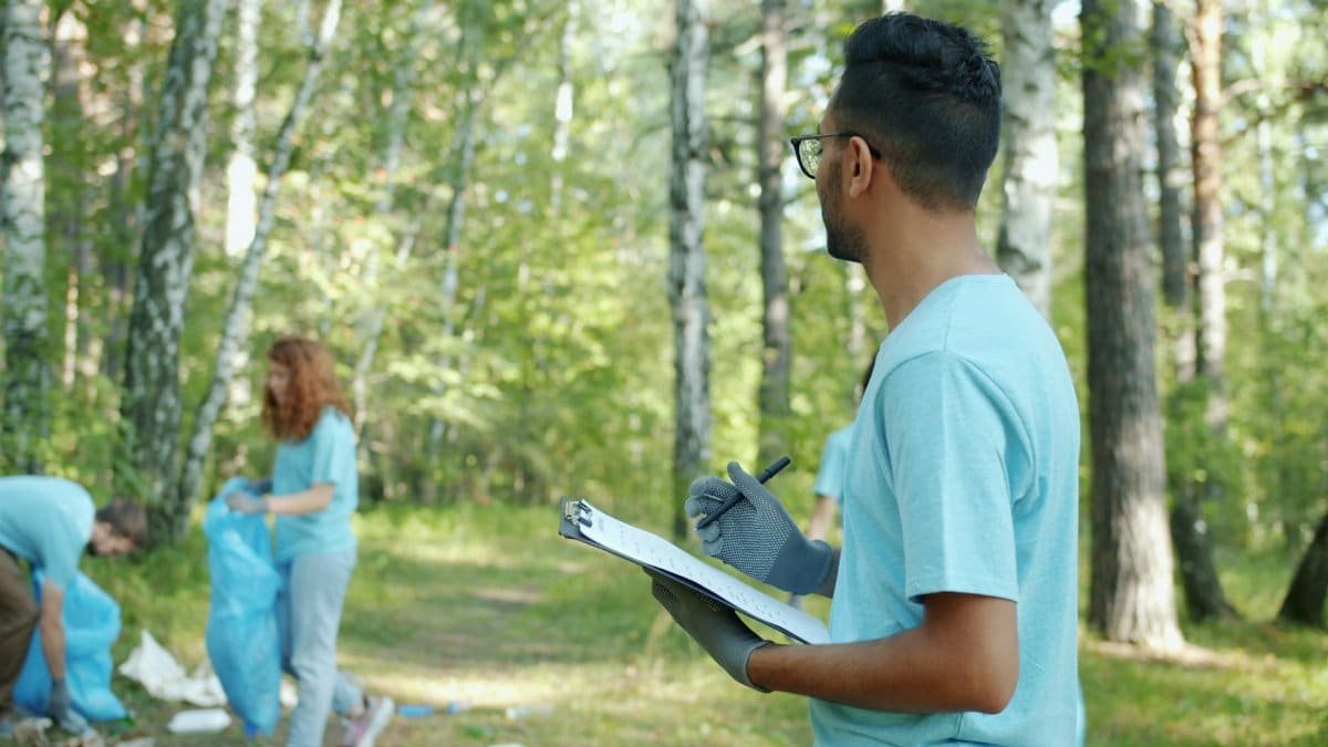 Volunteers collect litter in a forest, showcasing teamwork and environmental care.
