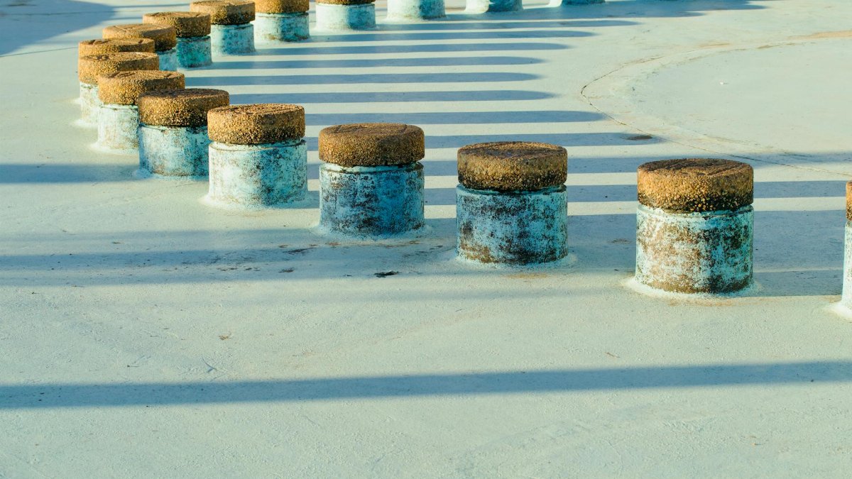 Artistic play of light and shadows on circular industrial structures outdoors.