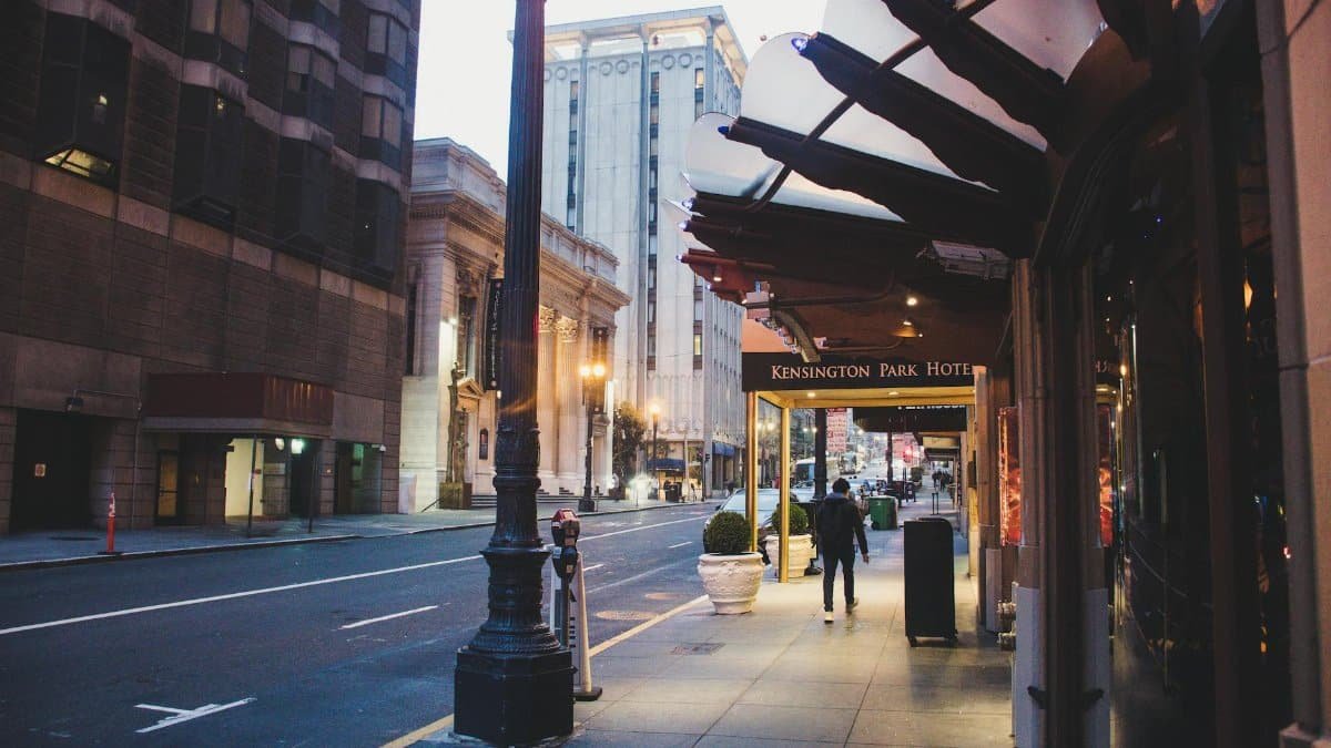 A city street view in the evening near Kensington Park Hotel with a man walking.