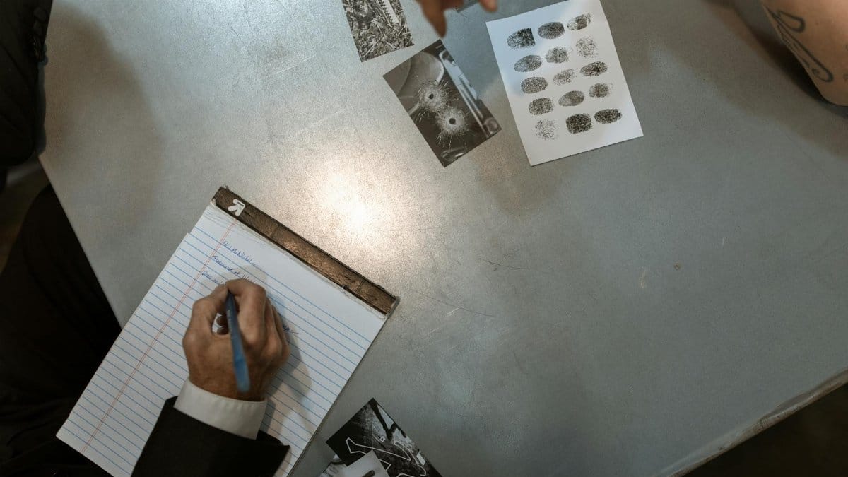 Officers at work reviewing evidence and taking notes in an investigation setting.