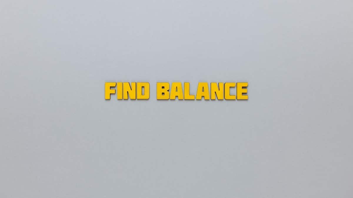 Yellow text 'Find Balance' displayed on a minimalist grey backdrop for motivation.