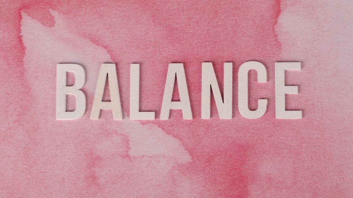 The word 'BALANCE' displayed in bold letters on a pink abstract background.
