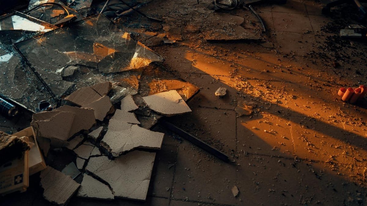 A dramatic scene of shattered glass and debris in warm lighting, symbolizing urban decay.