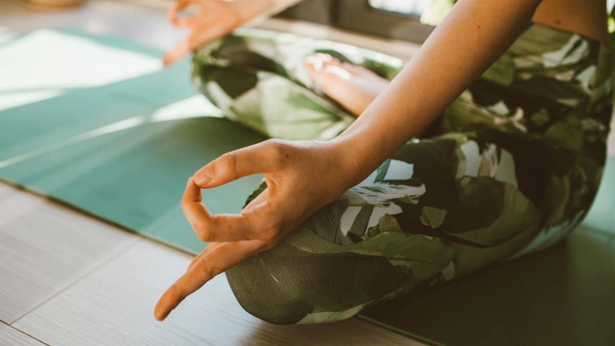 Serene close-up of woman practicing yoga on a mat indoors in natural light.