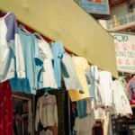 Colorful clothing on display at a bustling Chinatown market in San Francisco.