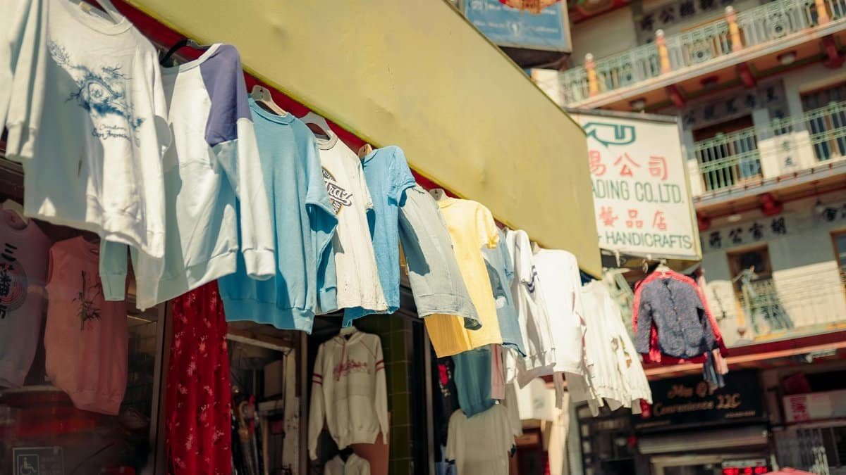 Colorful clothing on display at a bustling Chinatown market in San Francisco.