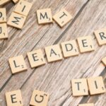 Wooden Scrabble tiles on a table spelling 'Leader' symbolize leadership and strategy.