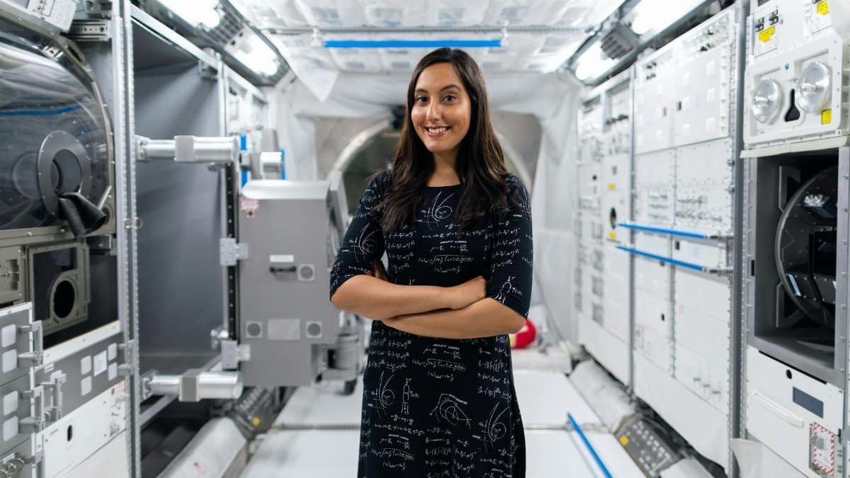 A smiling female scientist in a futuristic space station, symbolizing innovation and exploration.