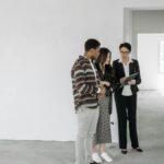 A couple and realtor discuss details in an unfinished property. Ideal for real estate themes.
