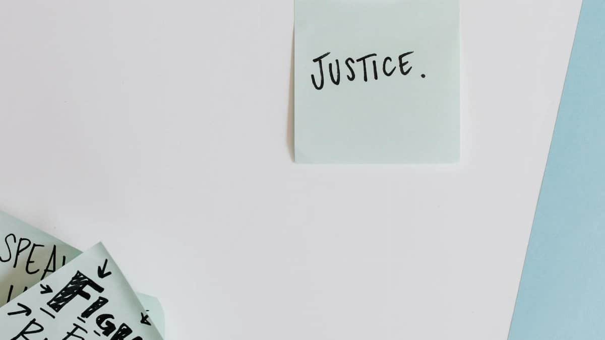 Sticky notes with messages on justice and rights on a flat surface.