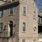 Charming stone house with colonial architecture in Newtown, PA on a sunny day.