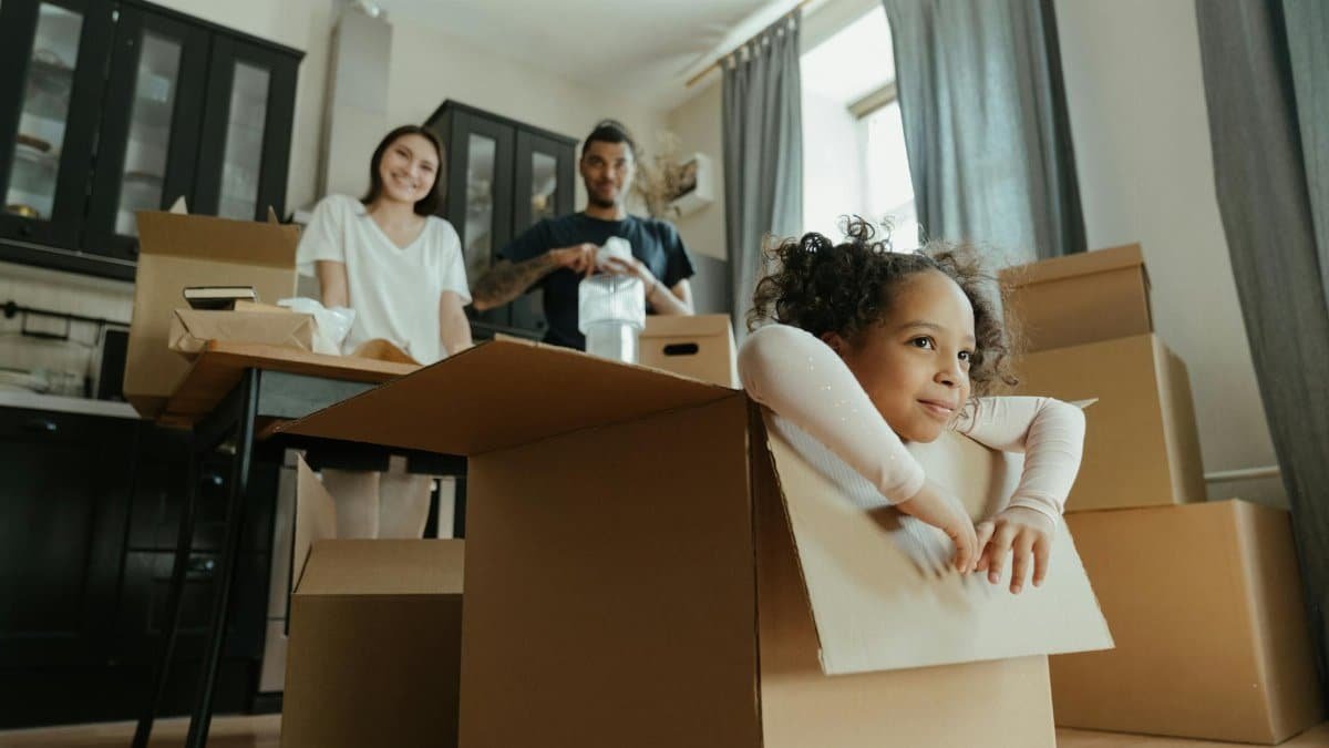 Family enjoys a joyful moment while unpacking boxes in their new kitchen.