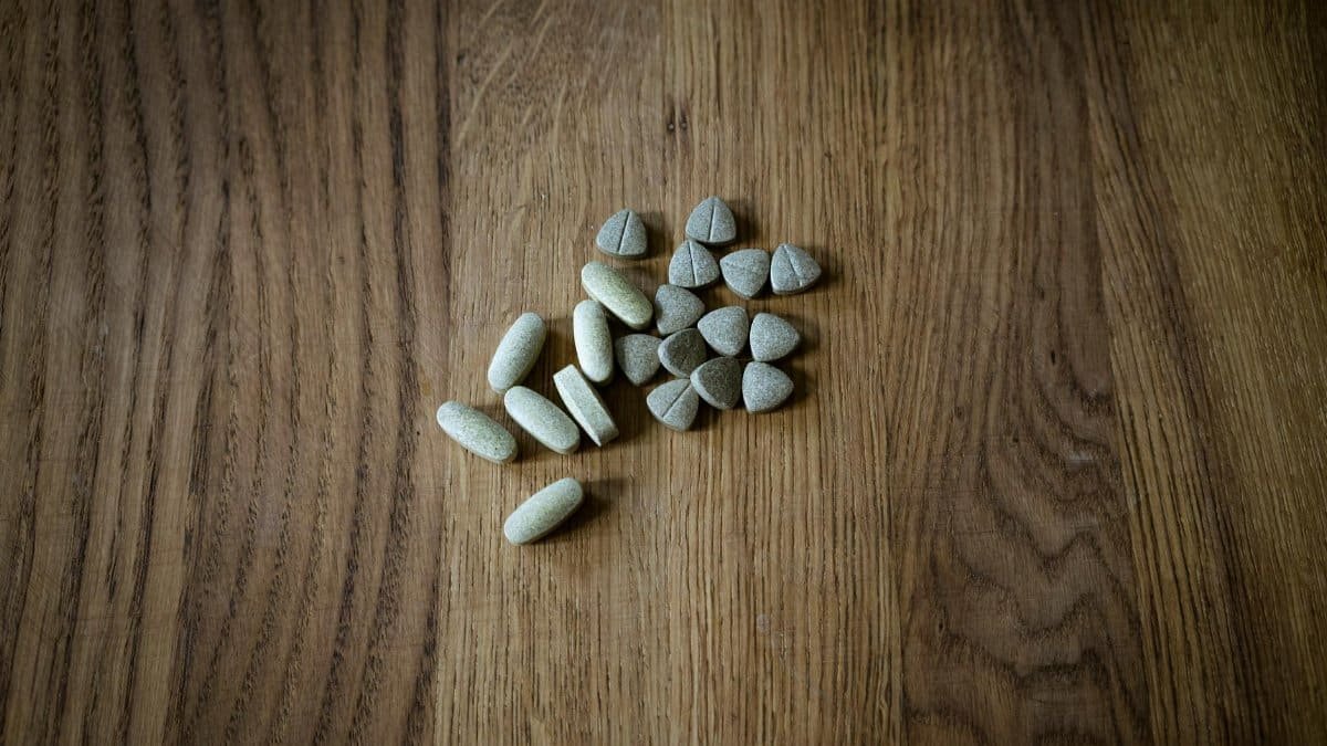 From above of set of different assorted medical pills arranged on lumber surface