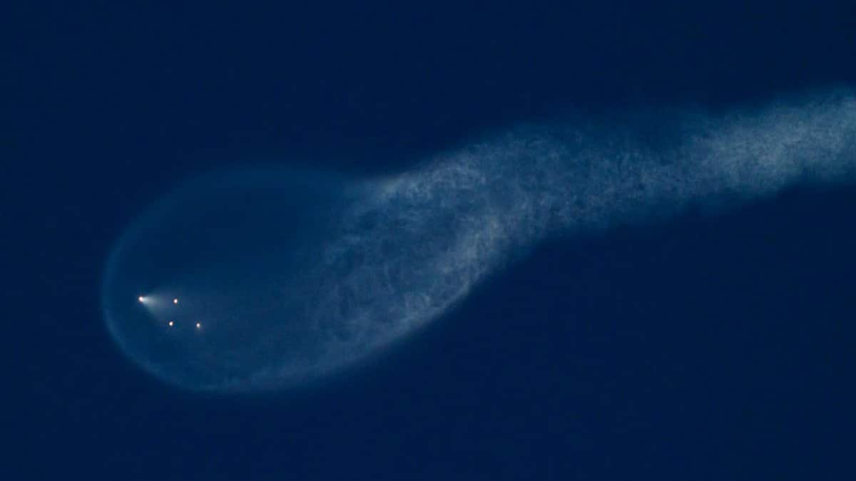 Ethereal view of a mysterious illuminated trail in the night sky, resembling an astronomical phenomenon.