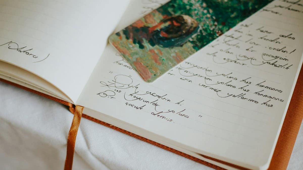 A close-up of an open journal with handwritten text and a colorful bookmark, evoking creativity.