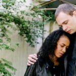 A couple embraces outdoors, conveying an emotional connection. Perfect for themes of love and empathy.
