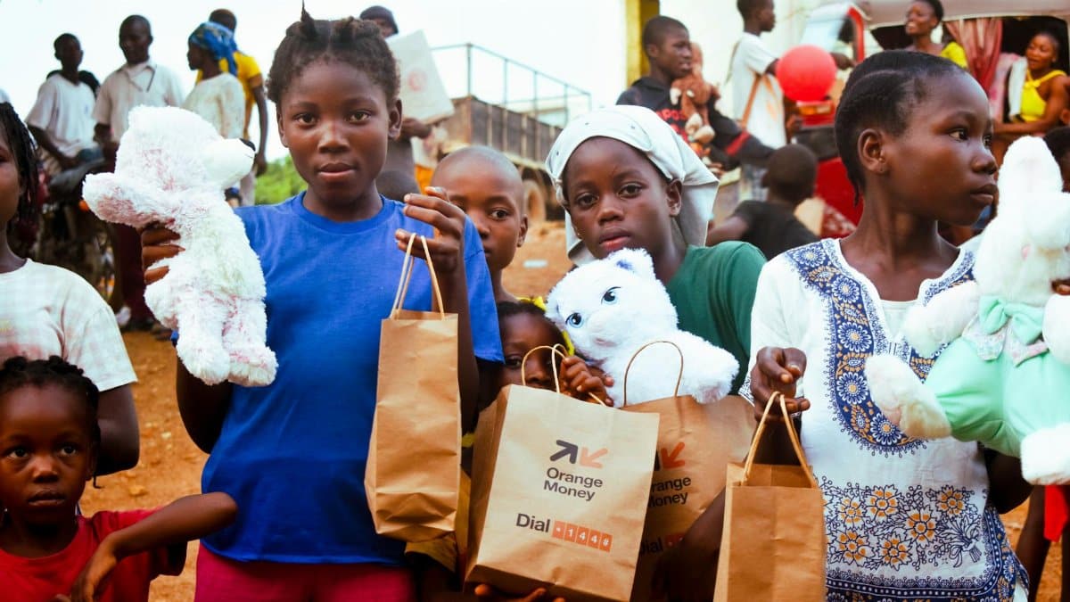 Children in Monrovia, Liberia hold stuffed toys and gift bags during a community event.