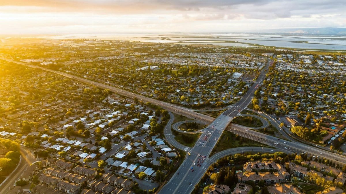 Sunset aerial view of a bustling urban intersection with surrounding residential areas.
