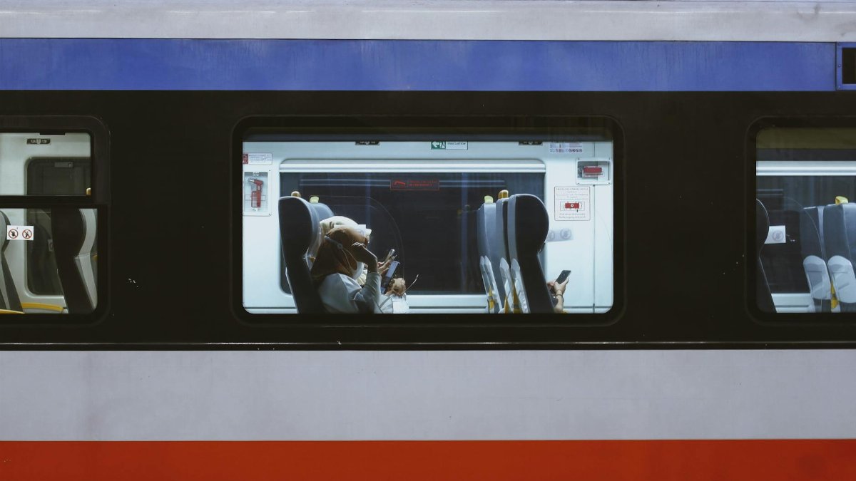 Passengers inside a train using cellphones, public transport setting.