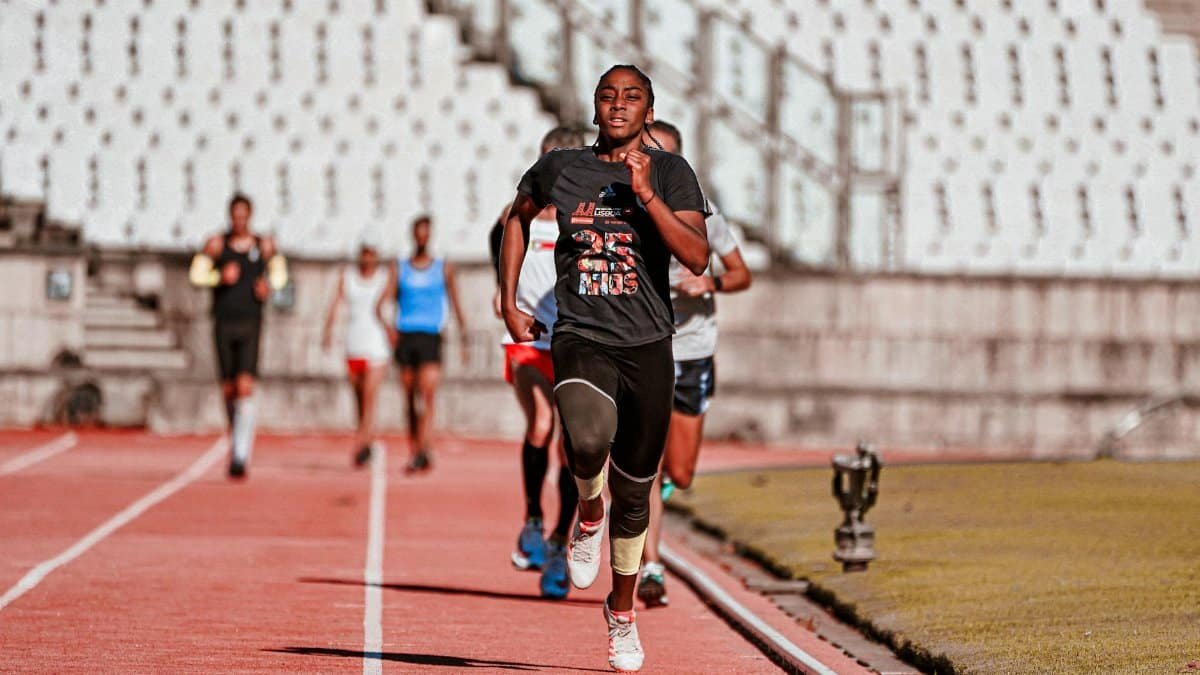 Focused athletes sprinting on a track during outdoor competition.