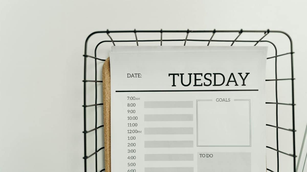 Top view of a minimalist Tuesday planner on a wire basket for organization and scheduling.
