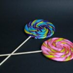 Bright and colorful swirl lollipops on a black background showcasing candy artistry.