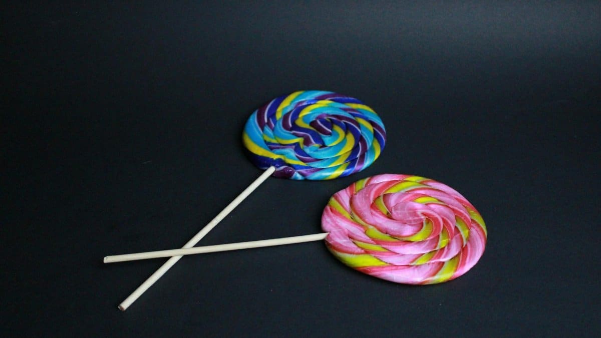 Bright and colorful swirl lollipops on a black background showcasing candy artistry.