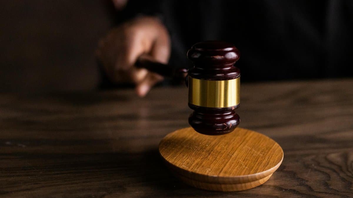A gavel striking a sound block, symbolizing justice and legal authority in a courtroom setting.