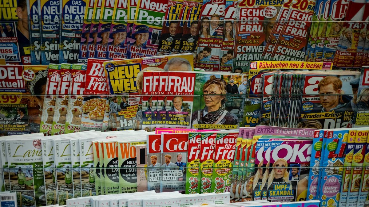 A vibrant display of magazines in a newsstand, showcasing various colorful covers and headlines.