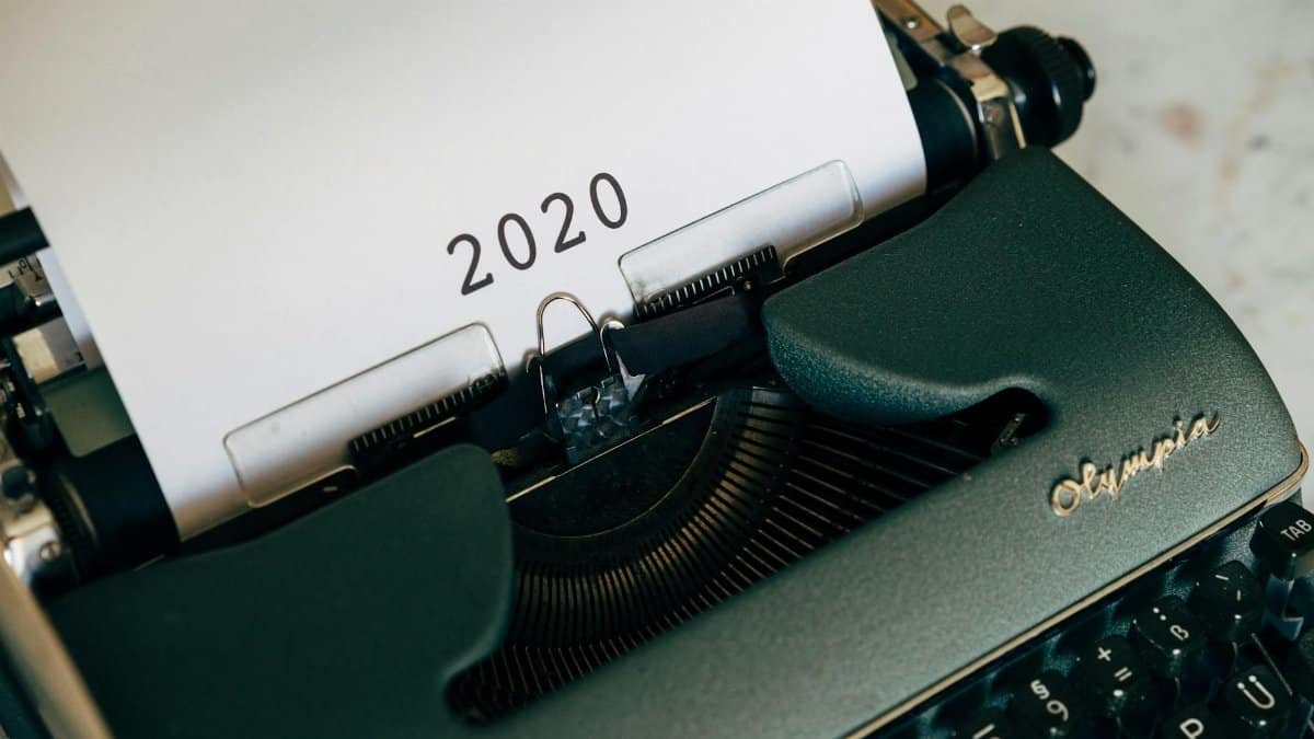 Close-up of a vintage typewriter with the year 2020 on paper, symbolizing past communication.