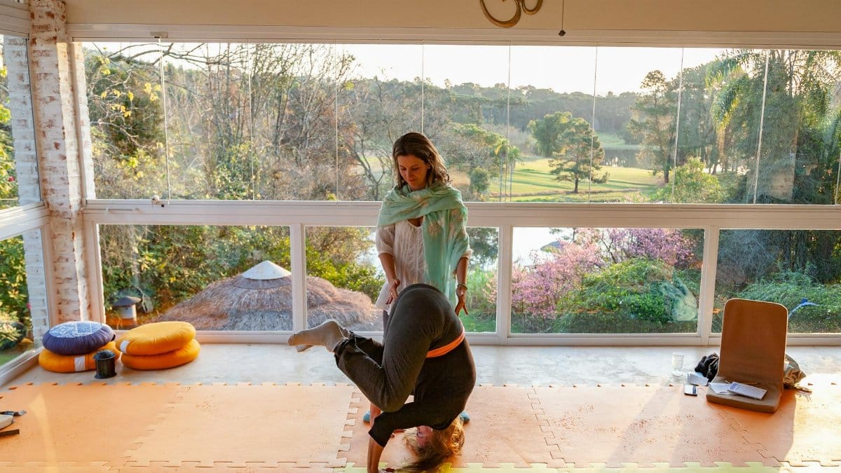 A serene yoga practice indoors with a view of lush greenery, capturing balance and mindfulness.