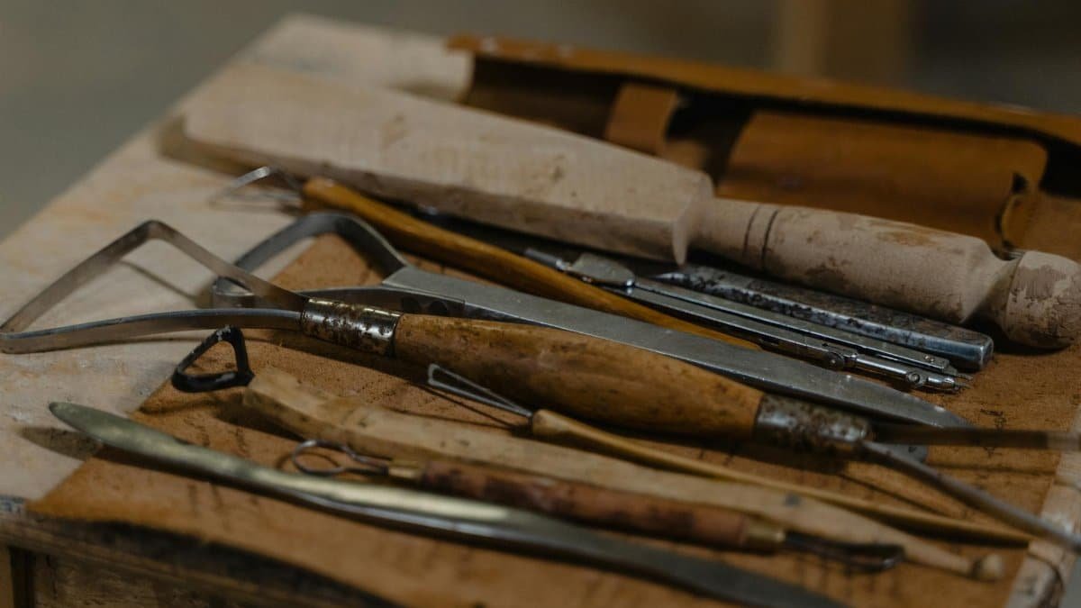A collection of artisan tools arranged on a workshop table, showcasing craftsmanship.
