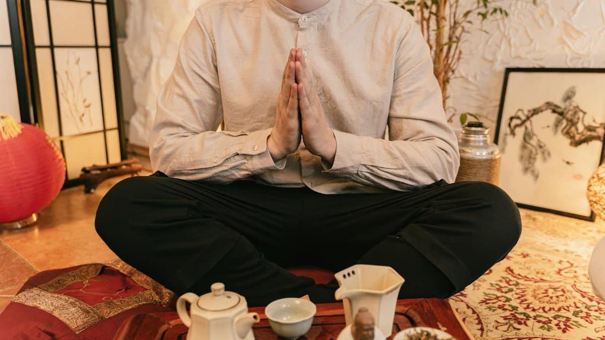 A serene tea ceremony with a man practicing mindfulness indoors.