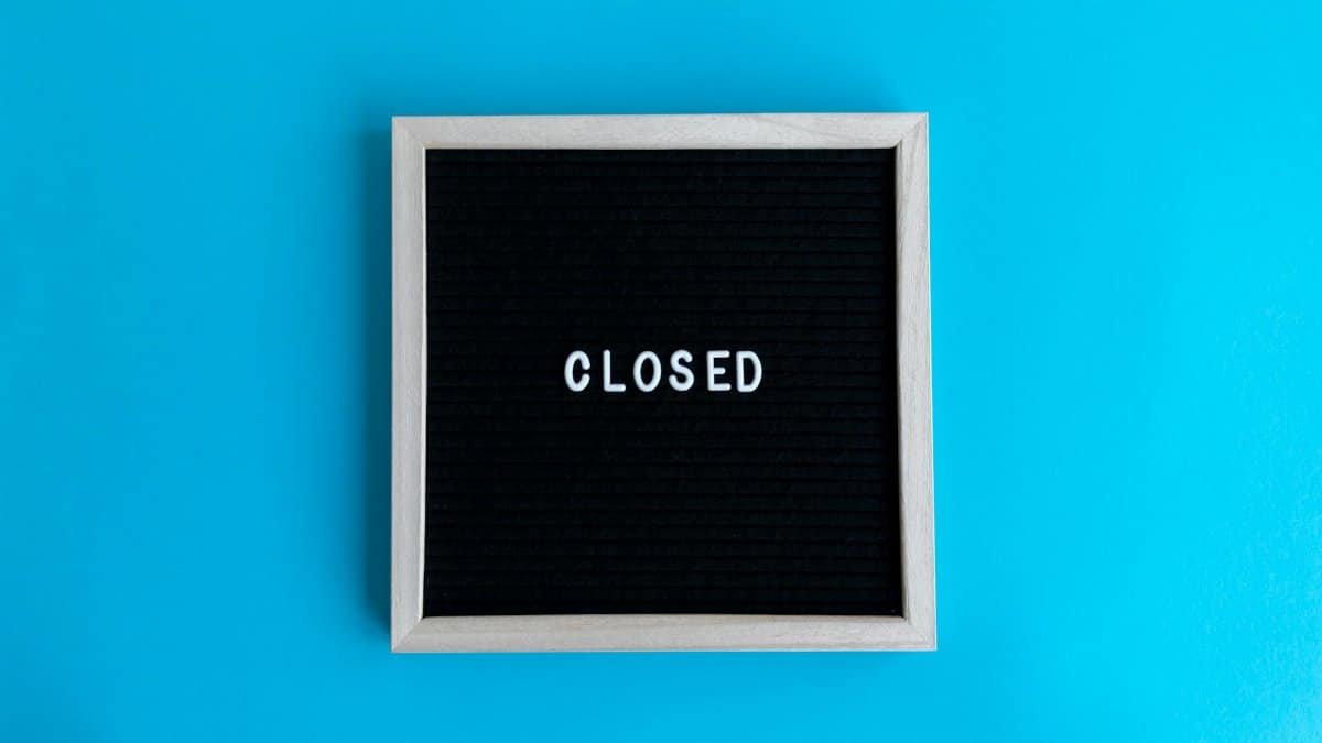 A letter board with 'Closed' displayed against a vibrant blue backdrop, signifying a closure or notice.