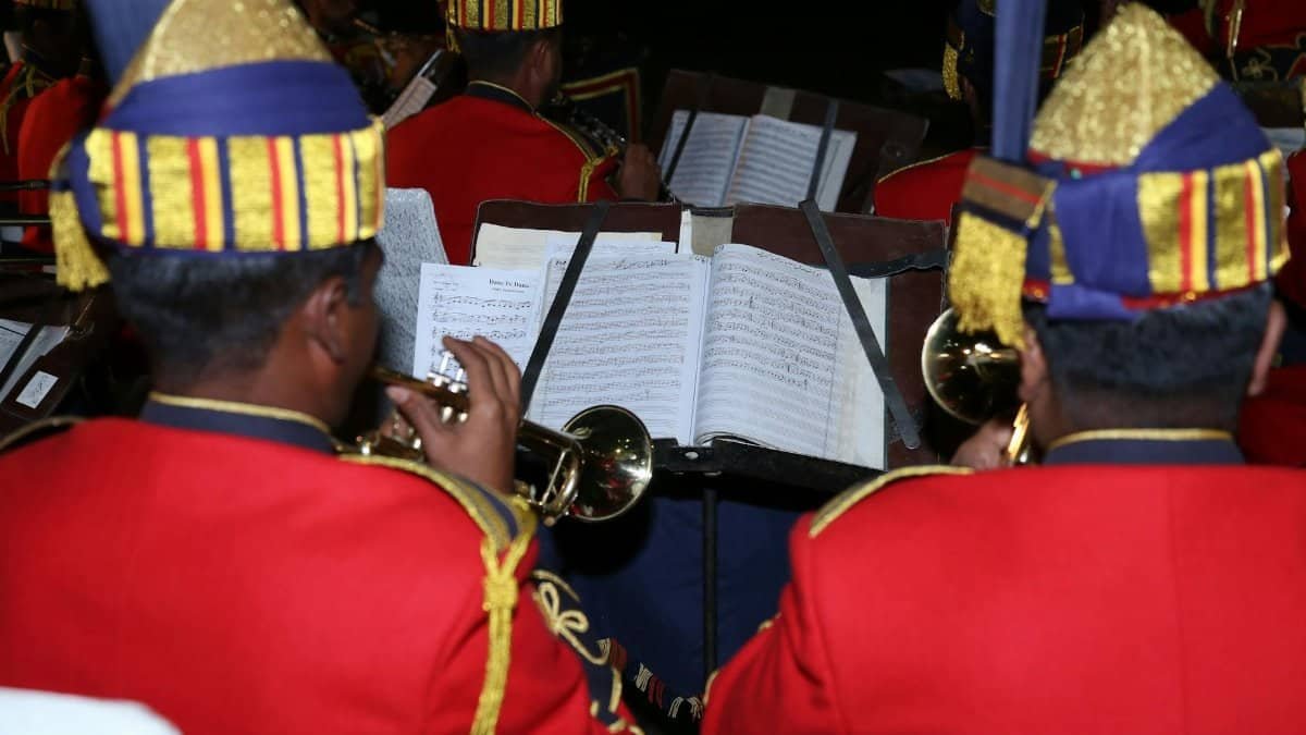 A brass band dressed in vibrant uniforms performing a musical concert.