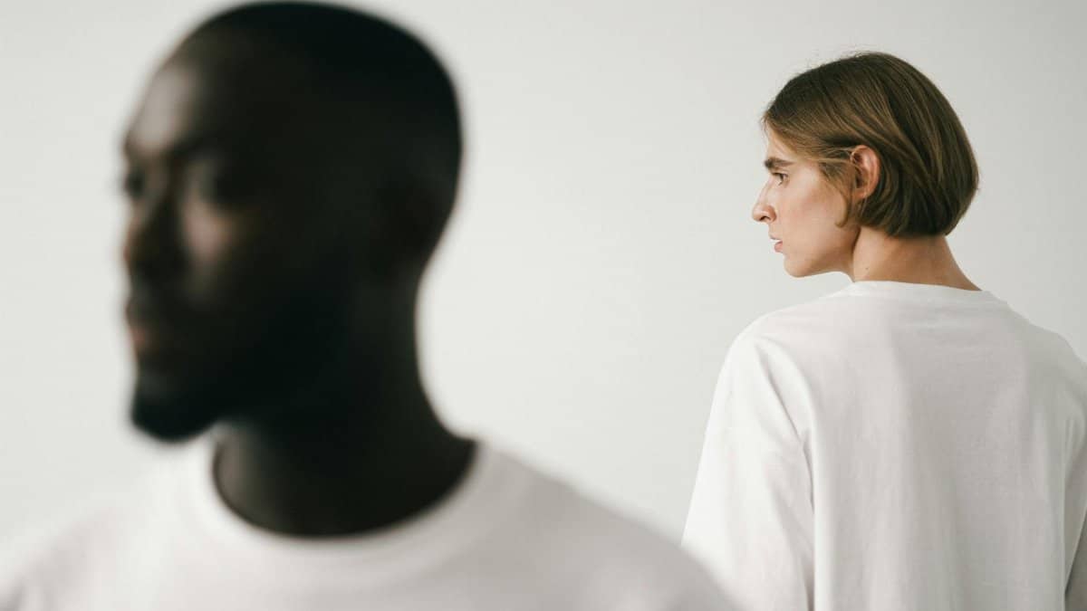 Stylish studio portrait of two models, emphasizing minimalist fashion in white t-shirts.