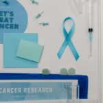 Flat lay showing cancer awareness items with blue ribbon and research tools.