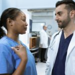 Medical professionals discussing patient care in a hospital hallway.
