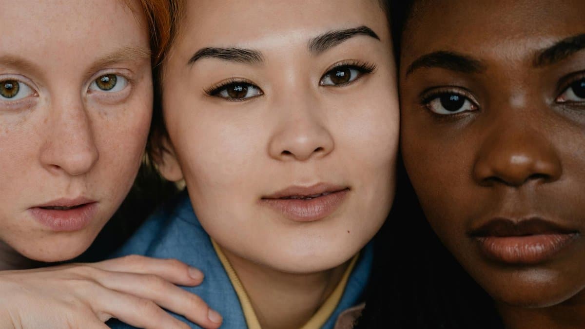 Close-up portrait of three diverse women showcasing natural beauty and diversity.
