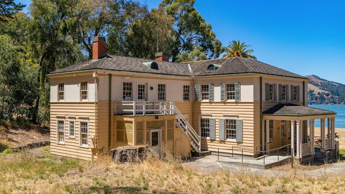 Old mansion at Angel Island State Park with ocean view and natural landscape under clear blue sky.