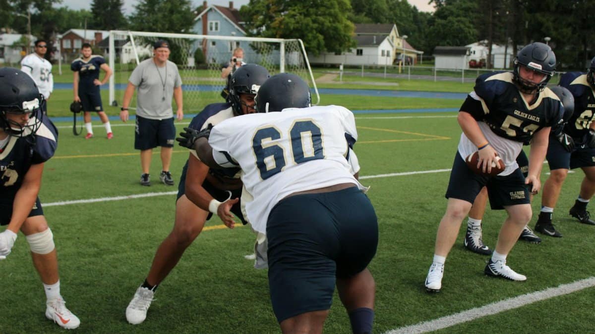 Dynamic scene of American football players in action during practice. Focus on teamwork and strategy.