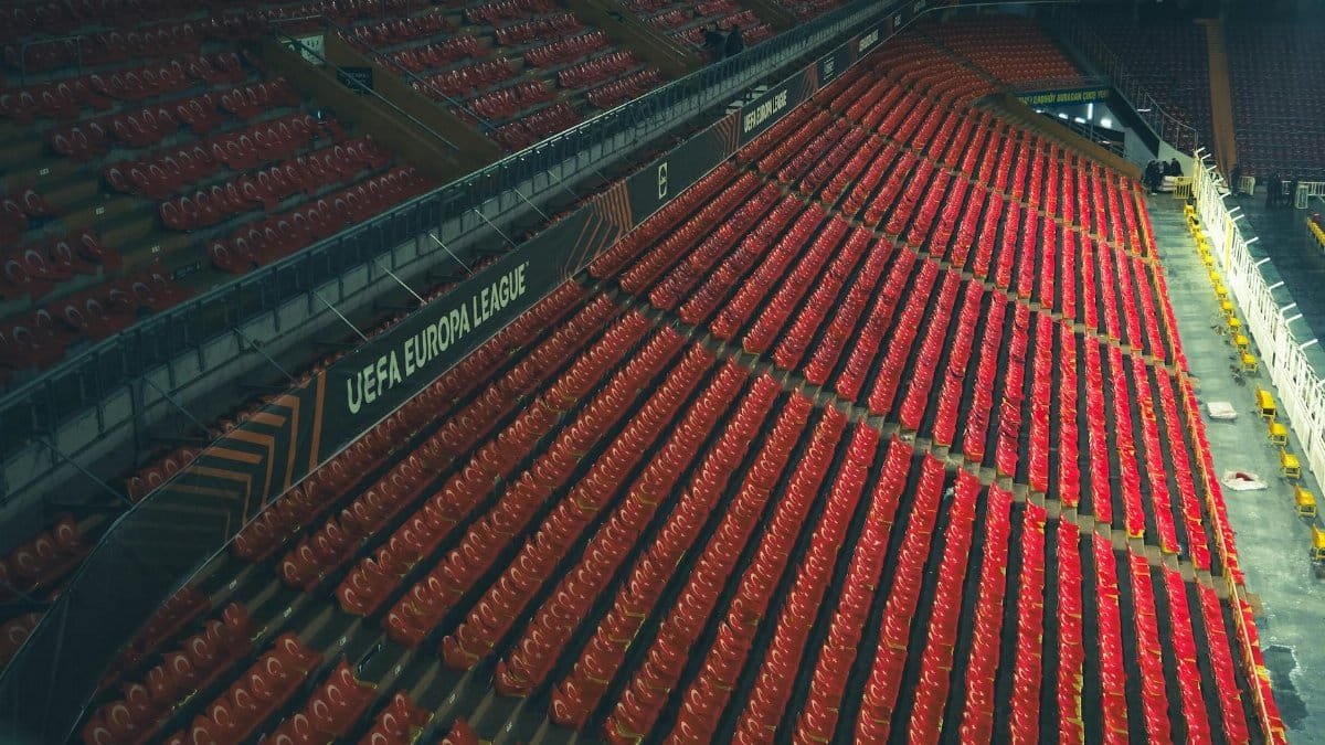 Rows of red seats in an empty stadium with UEFA Europa League signage.