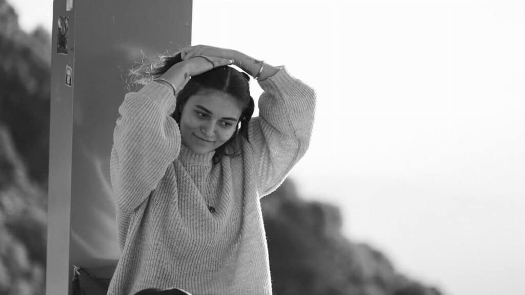 A serene black and white portrait of a woman enjoying a relaxed moment outdoors.