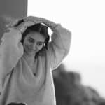 A serene black and white portrait of a woman enjoying a relaxed moment outdoors.