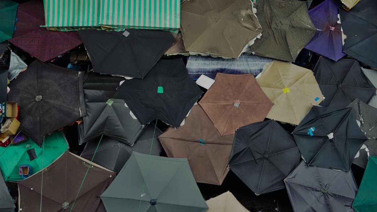 Top-down view of overlapping market umbrellas creating a vibrant geometric pattern.