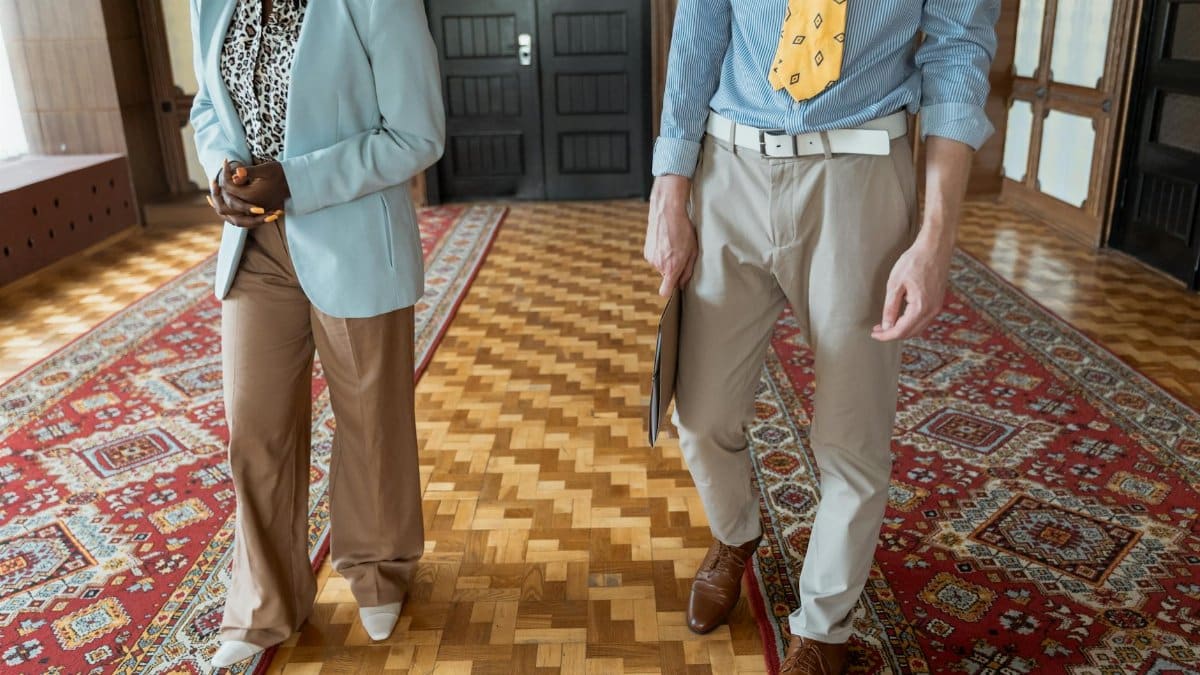 Two professionals in stylish business attire walking inside a stylish office building.