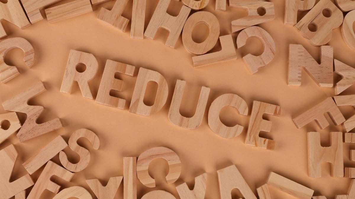 Top-view image of scattered wooden alphabet blocks with 'Reduce' prominently displayed.