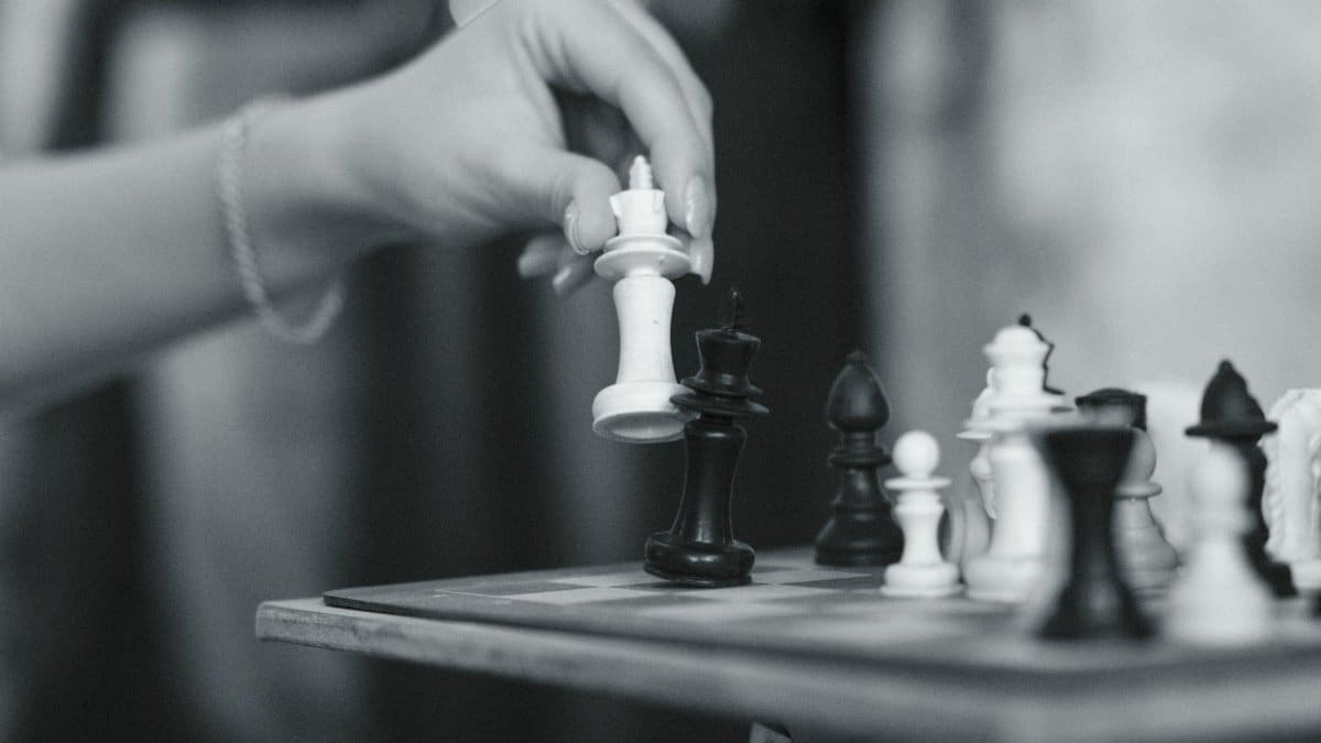 Black and white image capturing a strategic chess move with a wooden chessboard in Eskişehir.