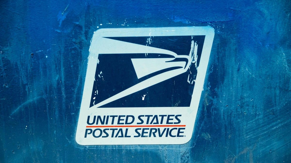 Detailed view of the United States Postal Service logo on a blue background, showcasing texture.