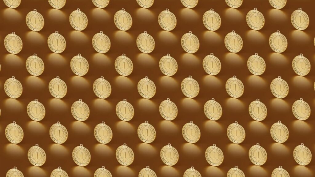 Multiple gold medals arranged in a repeating pattern on a brown backdrop.